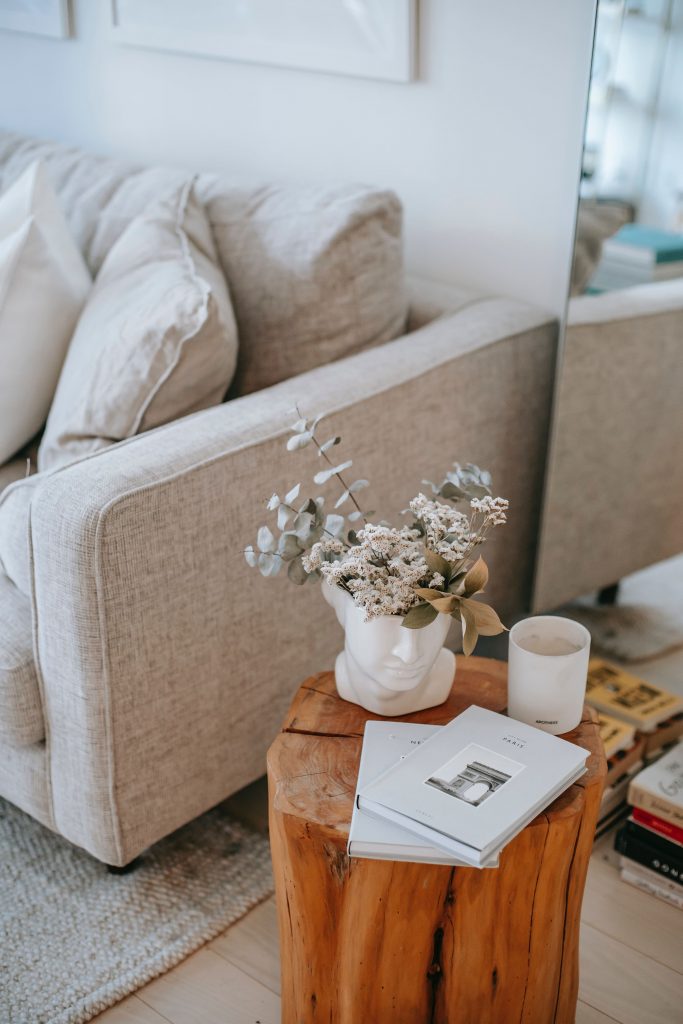 mesa auxiliar de madera de estilo nórdico y sofá beige