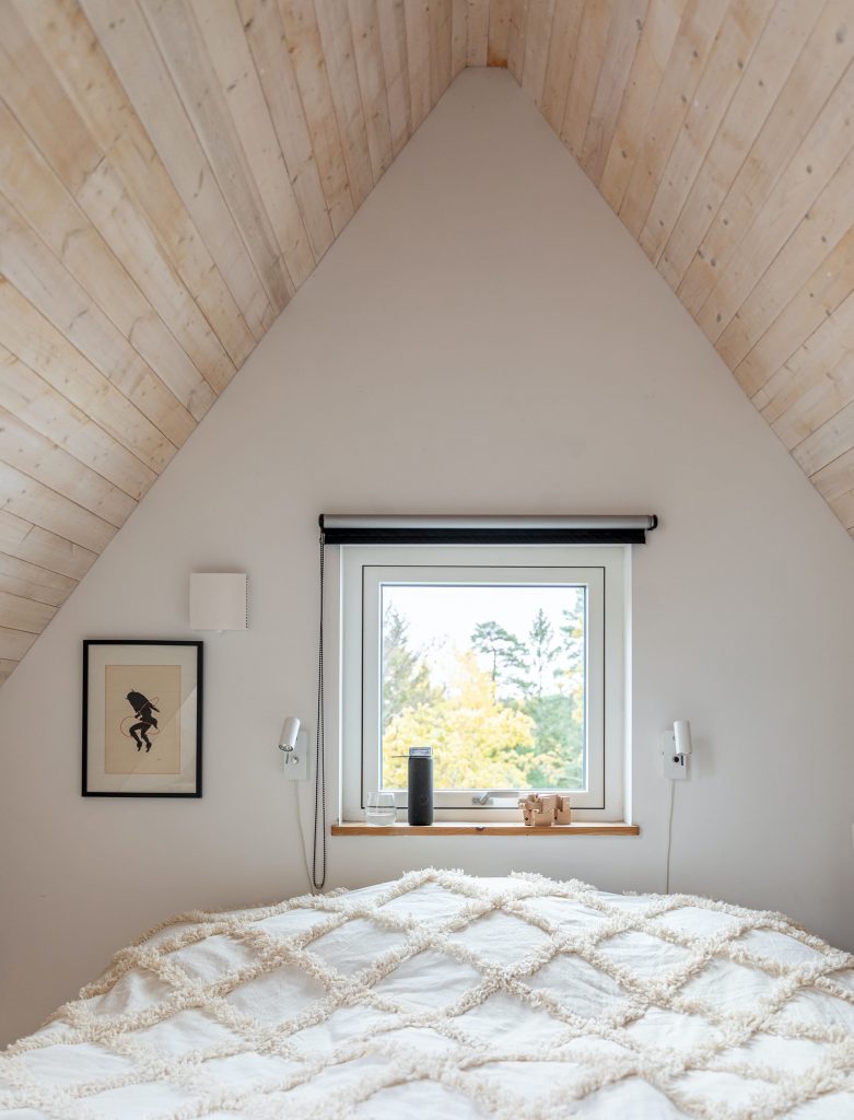 habitación con el echo de madera y ventana blanca